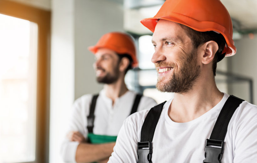 Zwei Monteure sehen glücklich am Arbeitsplatz aus