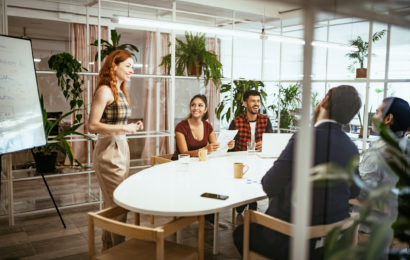 Gut gelauntes Team hat ein Meeting in hellem begrünten Büroraum