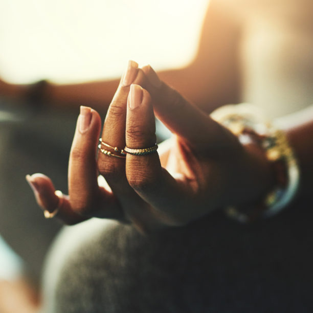 MEDISinn Angebot Meditation Frau meditiert im Schneidersitz, die Hände auf den Knien, Daumen & Mittelfinger zusammen
